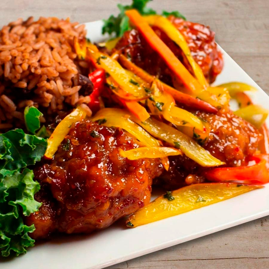 Meat in sauce and vegetables with side of rice and beans