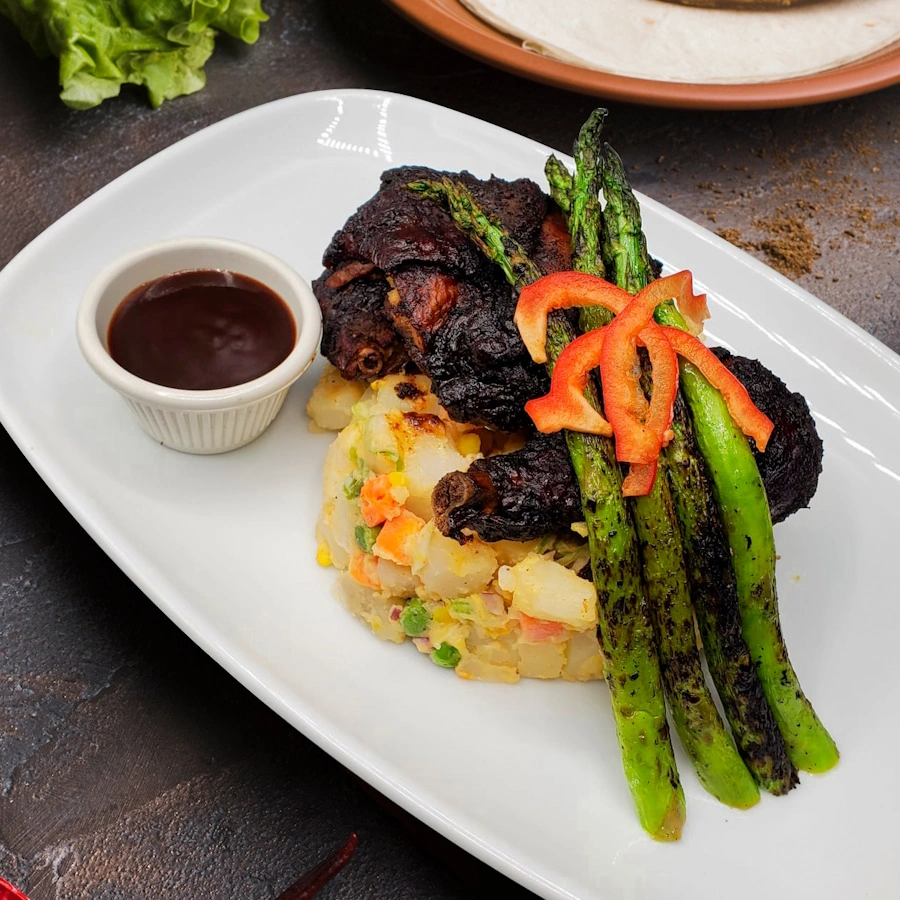 Mashed potatoes with vegetables accompanied by chicken and sauce